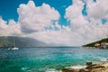 White yacht going to open sea under amazing white endless cloudscape. Crystal clear transparent blue turquoise water in Royalty Free Stock Photo