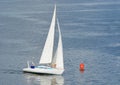 White yacht making a close turn near buoy