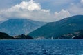 White yacht with a sail in the sea against the backdrop of the coastline of the mountains Royalty Free Stock Photo