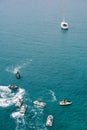 White yacht sails on the sea with jet skis.