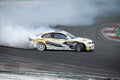 White yellow BMW E36 producing smoke on a trail for a drift competition