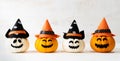 White and yellow ghost pumpkins with witch hat on white wooden borad background. Halloween decoration concept