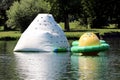 White and yellow green inflatable floating climbing walls in different shapes and sizes on calm river surface Royalty Free Stock Photo