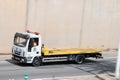 White and yellow Iveco Eurocargo crane truck circulating along the Ronda litoral de Barcelona
