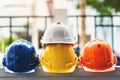 White, yellow and other colored safety helmets for workers` safety projects in the position of engineers or workers on concrete Royalty Free Stock Photo