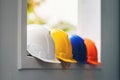 White, yellow and other colored safety helmets for workers` safety projects in the position of engineers or workers on concrete Royalty Free Stock Photo
