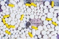 White and yellow pills on a money background
