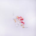 white and yellow pills, red-pink capsules on a white background Royalty Free Stock Photo