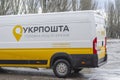 White and yellow postal van on rainy city street