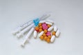 White, yellow and rose tablets pills and three syringes on the table Royalty Free Stock Photo