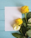 White and yellow roses beauty vintage on a blue wooden background place for text blank white card