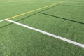 White and yellow stripes on green soccer field from side view. Artificial turf on football field. Green synthetic grass Royalty Free Stock Photo