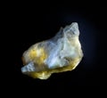 White yellow talk mineral from Ural, Russia. A backlight photo of a stone isolated on black. Geology websites, stone collection