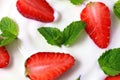White yoghurt with fresh red juicy strawberry pieces and green mint leaves close up Royalty Free Stock Photo