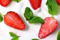 White yoghurt with fresh red juicy strawberry pieces and green mint leaves close up Royalty Free Stock Photo