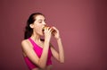 Studio shot of hungry woman with sandwich