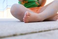 White young girl child feet on a rough stone ground