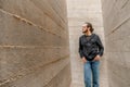 White young handsome man standing near the wall and look up. Portrait of fashion guy in blue jeans and casual wear smiling Royalty Free Stock Photo