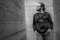 White young handsome man standing near the wall and look up. Portrait of fashion guy in blue jeans and casual wear smiling Royalty Free Stock Photo