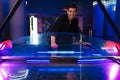 White young man laughing while playing air hockey