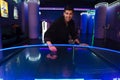 White young man laughing while playing air hockey