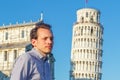 A white young man posing in front of the Leaning Tower in Pisa
