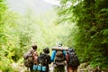 Young travelers with backpacks hiking together in forest