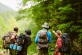 Young travelers with backpacks hiking together in forest