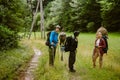 Young travelers with backpacks hiking together in forest