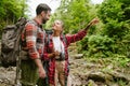 Young travelers wearing backpacks hiking in forest