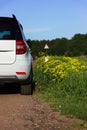 White youth car parked by the side of the road during a travel picnic. Outdoor weekends, local travel