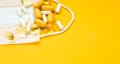 White and yellow pills on  medical mask. intence yellow paper background Royalty Free Stock Photo