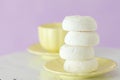 White zephyr dessrt on yellow plate, cup of coffee with milk on pastel violet background. Beautiful sweets. Horizontal banner, gre Royalty Free Stock Photo