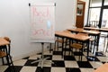 A whiteboard in empty classroom with lettering Back to school and medical mask attach, new normal Royalty Free Stock Photo