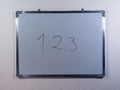 Whiteboard showing 123 concept on clean white wall background representing counting, learning numbers and education Royalty Free Stock Photo