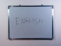 Whiteboard showing ENGLISH concept on clean white wall background representing language learning and education Royalty Free Stock Photo