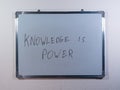 Whiteboard showing KNOWLEDGE IS POWER message on clean white wall background representing education, learning and personal growth Royalty Free Stock Photo