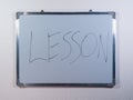 Whiteboard showing LESSON concept on clean white wall background representing education, learning and teaching process Royalty Free Stock Photo