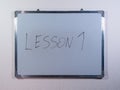 Whiteboard showing LESSON concept on clean white wall background representing education, learning and teaching process Royalty Free Stock Photo