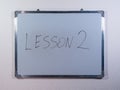 Whiteboard showing LESSON concept on clean white wall background representing education, learning and teaching process Royalty Free Stock Photo