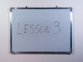 Whiteboard showing LESSON concept on clean white wall background representing education, learning and teaching process Royalty Free Stock Photo