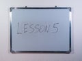 Whiteboard showing LESSON concept on clean white wall background representing education, learning and teaching process Royalty Free Stock Photo