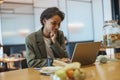 A whitecollar worker sits at a table using a laptop computer