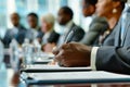 Whitecollar workers are sharing ideas at a desk in a conference room. The table is adorned with tableware and office