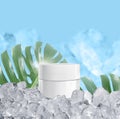 Whitening cream in a glistening white spherical base packaging with ice cubes on blue background and tropical plants, for cosmetic