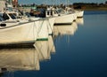 White fishing boats reflecting in water Royalty Free Stock Photo