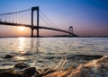 Whitestone Bridge in Queens, New York City at sunset with the water of the Long Island Sound in view.