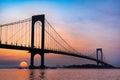 Whitestone Bridge in Queens, New York City at sunset with the water of the Long Island Sound in view.