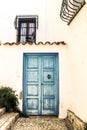 Whitewashed facade with blue wooden door Royalty Free Stock Photo