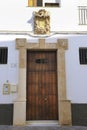 Whitewashed facade with carved stone coat of arms in Rota city, Andalusia